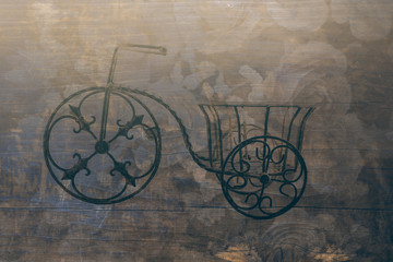 Fototapeta na wymiar a small metal bicycles blended on roses and wood planks background, filtered tones