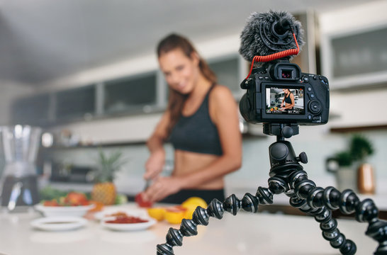 Young female blogger recording content for videoblog in Kitchen.