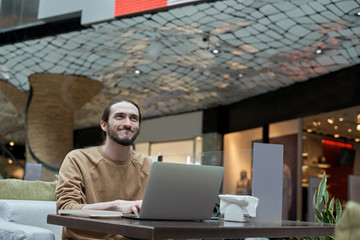 Evil genius. Happy and smiling stylish bearded man work in cafe. Internet joker type messages in social network. Successful online businessman get payment in online shop. Remote working.