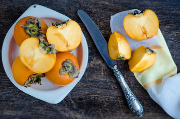 Naklejka na ściany i meble Delicious fresh persimmon fruit on wooden table
