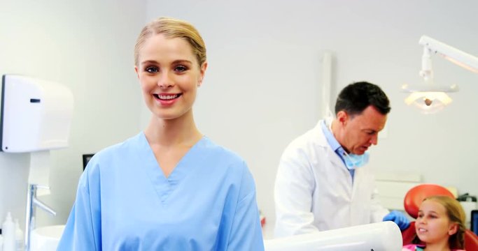 Portrait of smiling nurse standing in clinic