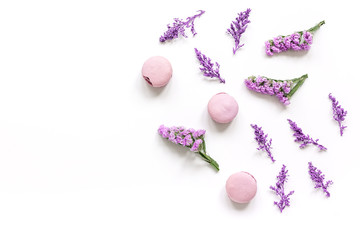 macaroons and flowers for light breakfast white desk background top view mockup