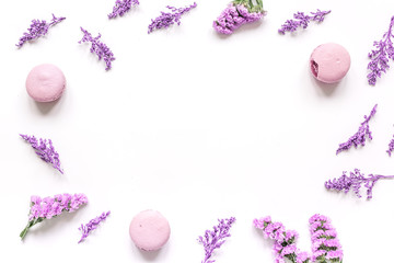 macaroons and flowers for light breakfast white desk background top view mockup