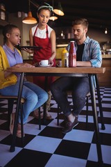 Waitress serving coffee to customer