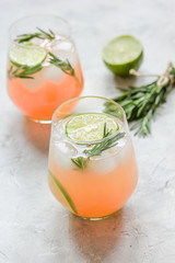 fitness cocktail in glass with lime and rosemary on stone table background