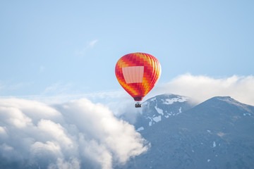 colorful air ballon over clouds and mountains