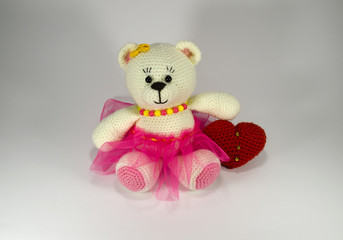 Knitted White Teddy Bear in pink skirt and beads with a big red heart. toy. handmade