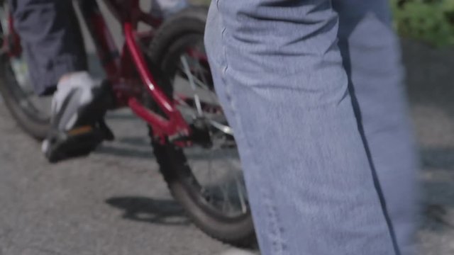 Man lets go of bike for child, close up