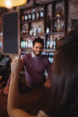 Obraz premium Woman asking for a drink to bar tender