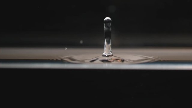 Drop of water makes ripples, slow motion