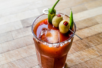 Bloody Mary Cocktail with green olive, pepper, salt and ice.