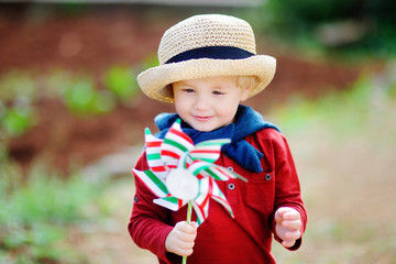 Happy toddler boy holding Italian flag outdoors