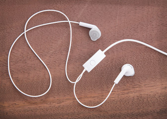 White headphones on the wooden background