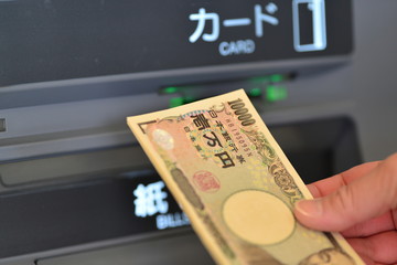a woman's hand withdrawing money at ATM