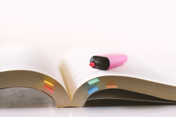 Education,Page of book with sticky note and highlighting pen on white background