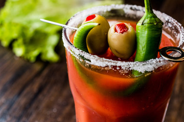 Bloody Mary Cocktail with green olive, pepper, lettuce, salt and ice.