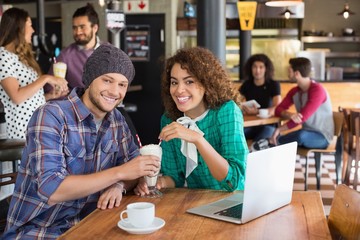 Portrait of smiling couple having milkshake 