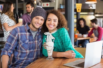 Portrait of smiling couple sitting in restaurant