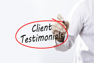 Businessman Hand Writing Client Testimonials with a marker over transparent board,  Business concept.