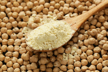 Natural organic chick pea flour in a wooden spoon