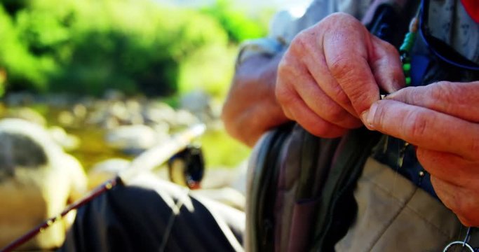 Fly fisherman preparing bait for fishing