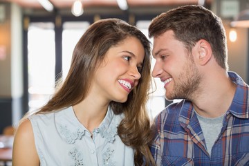 Young friends looking at each other in restaurant