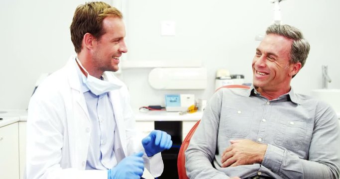 Smiling dentist and patient interacting with each other