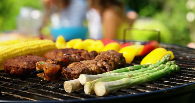 Grilling meat and vegetables on barbecue