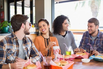 Friends talking while having lunch in restaurant