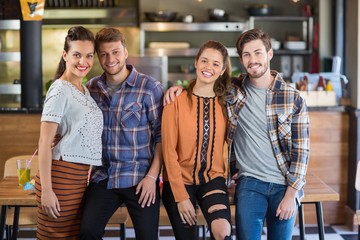 Portrait of friends leaning on table in restaurant