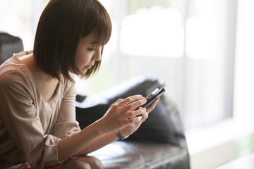 A woman is watching a smartphone at a cafe