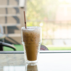 Iced coffee in a tall glass on wooden background