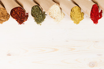 Varied powder spices close-up on  white wooden board with  copy space.
