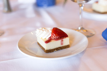 Cheesecake with cream and strawberry on the plate