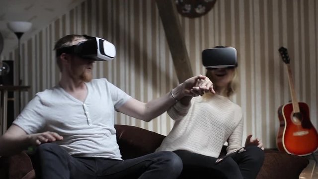 Couple Play a Roller Coaster in Virtual Reality Glasses in the Game Room