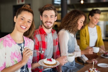 Friends having coffee and dessert in cafe
