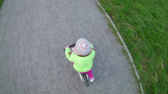 Child Sits on a Bicycle, Starts to Wheel, Little Girl is Riding a Bicycle