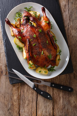 Home-baked duck stuffed with apples close-up on a plate. Vertical top view