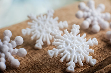 Snowflakes on a wooden background. Snow in the macro. Buttons in the form of snowflakes on a wooden board