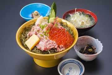 Bowl of fresh fish meat and red egg with sliced seaweeds and soup