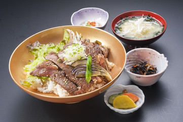 Bowl of rice with beefsteak, lettuce and soup in Japanese style