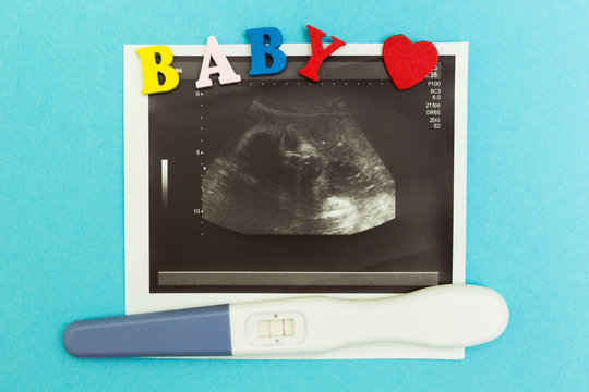 A positive pregnancy test with two strips, an ultrasound photograph and the word "baby" on a blue background.