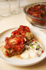 Chinese cabbage rolls on white dish with creamy cheese