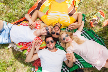 Fototapeta premium Happy people group young friends lying down on picnic blanket outdoor, two couple summer sunny day smile top angle view