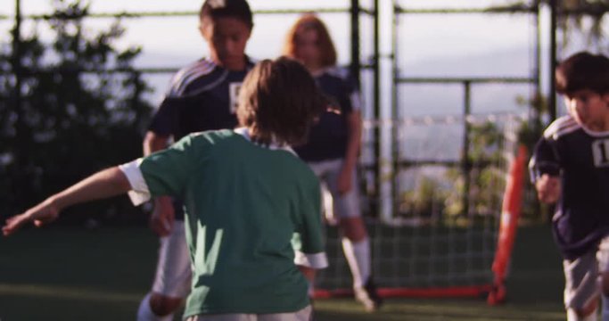 Youth league soccer players kicking the ball around the field