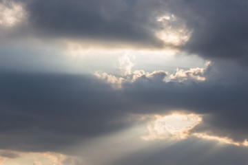 A close up of some dark clouds with powerful sunrays cutting through some holes