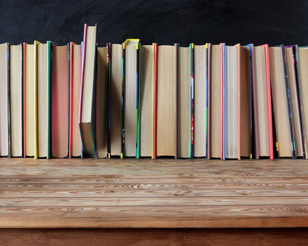 empty old wooden table on a background of books.