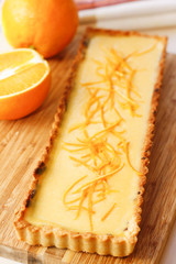 Cakes and biscuits with carrot and orange on wooden cutting board