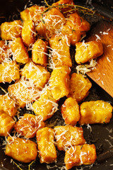 Pumpkin Nokia gnocchi on black pan with herbs