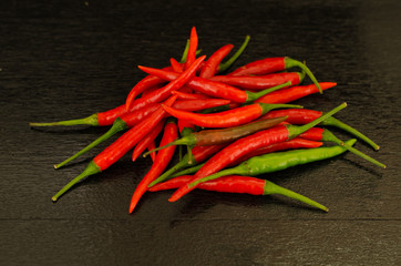Red hot chili peppers on black wooden background
